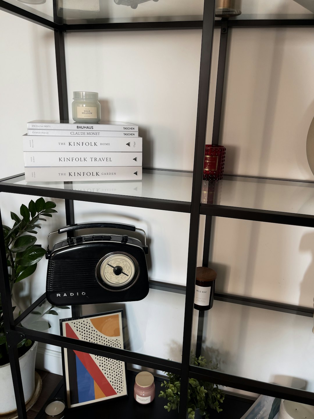 Moderne hyllesystem dekorert med bøker, planter og hjemmetilbehør.