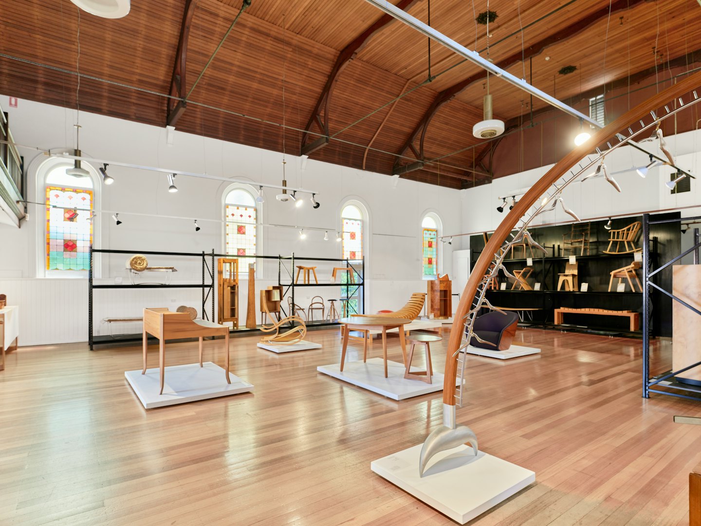Tredemøbler utstilt i et moderne gallerirom.